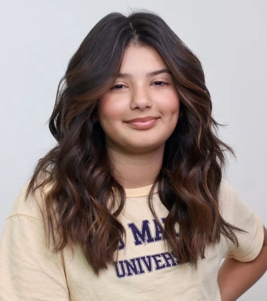 Coiffure longue et ondulée avec un balayage subtil pour les visages ronds